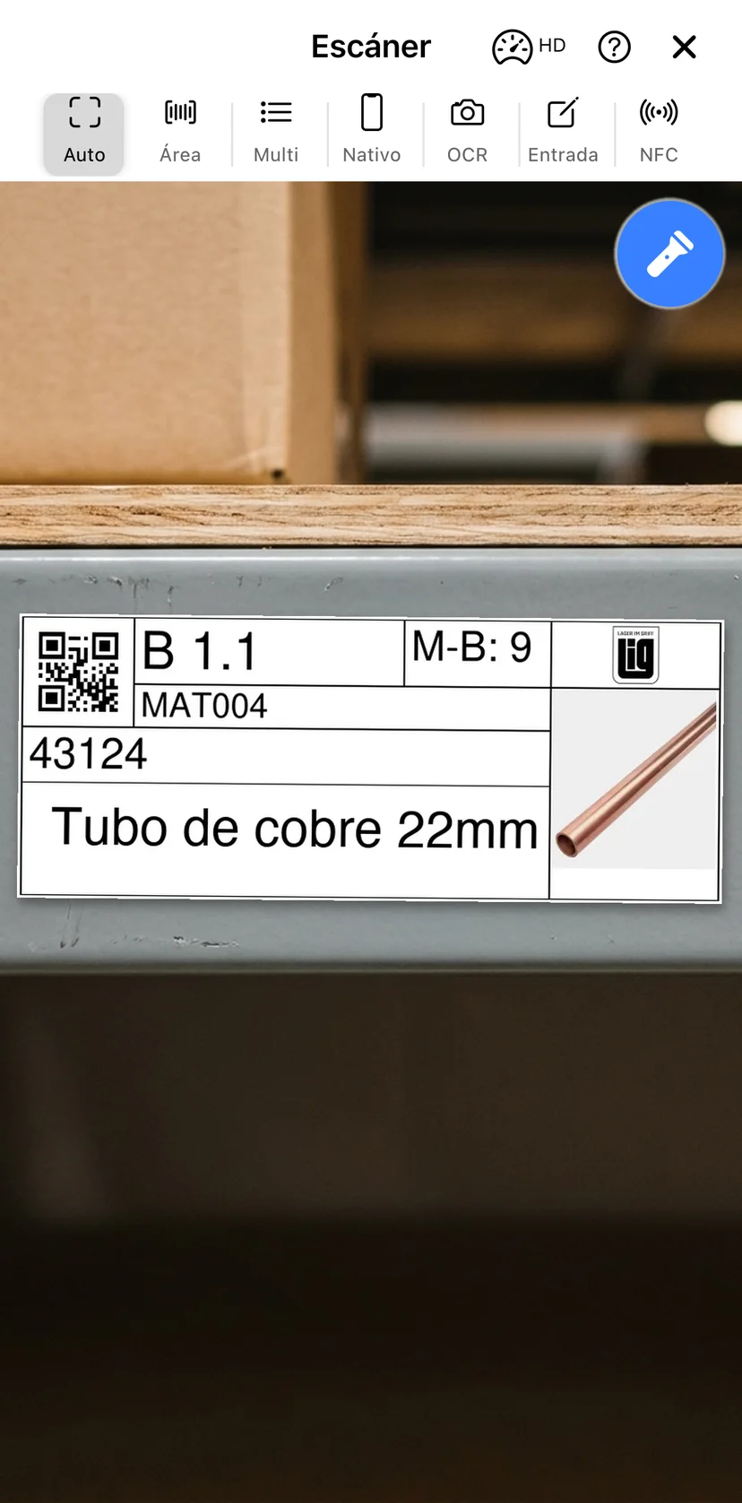 El escáner de la app móvil apuntando a una etiqueta QR impresa en una estantería de almacén